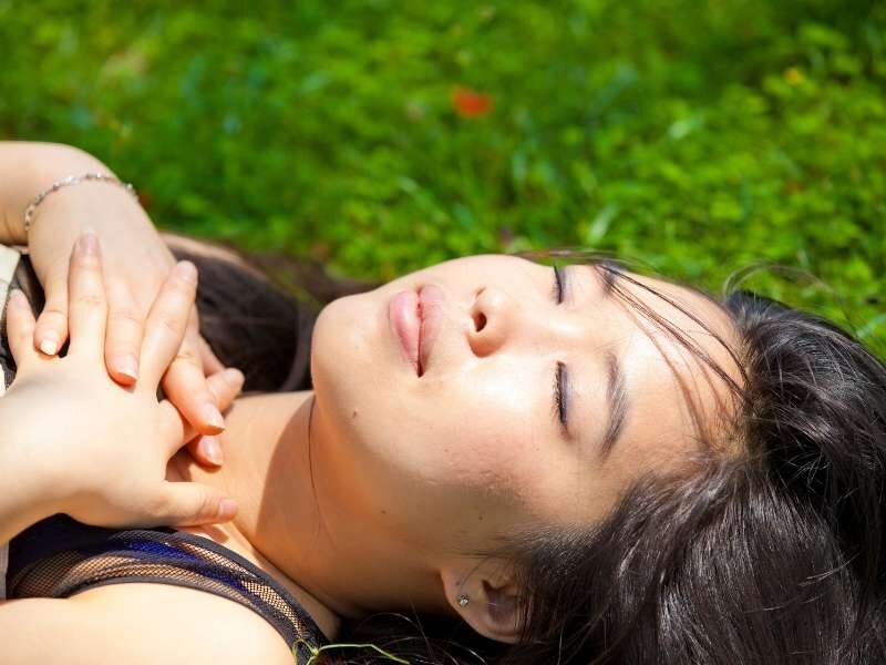 Mulher jovem tomando sol para melhorar a imunidade.