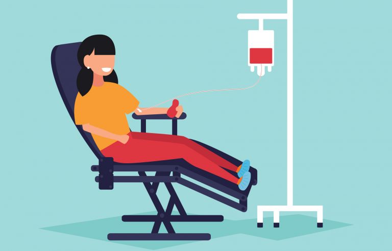 Na imagem, uma mulher aparece sentada numa maca reclinável. Ela está doando sangue.